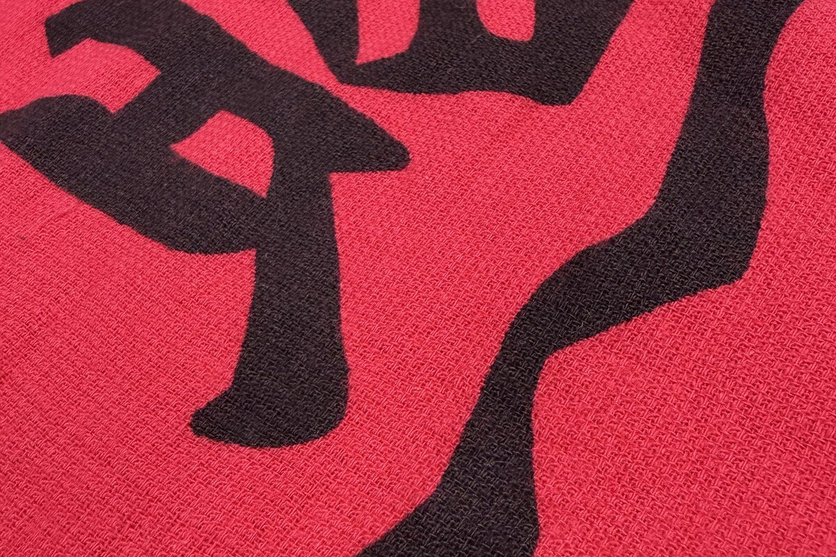 平織り面にシルクプリントした文字の拡大。繊維の凹凸が少ないため輪郭がはっきり出る